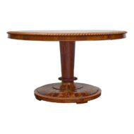 An English Regency walnut center table from circa 1840 with circular top and carved motifs